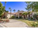 Luxury home with palm trees, circular driveway, and manicured lawn at 9840 N 111Th Pl, Scottsdale, AZ 85259