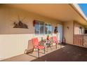 Covered patio with seating for two and potted plants at 10412 W Audrey Dr, Sun City, AZ 85351