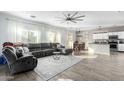 Spacious living room with L-shaped sectional sofa and hardwood floors at 23559 W Wayland Dr, Buckeye, AZ 85326