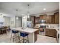 Modern kitchen with an island, stainless steel appliances, and dark wood cabinets at 2905 S 121St Dr, Tolleson, AZ 85353