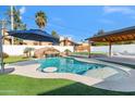 Relaxing pool area with a rock waterfall and covered patio at 708 E State Ave, Phoenix, AZ 85020