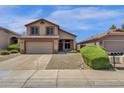 Two-story house with tan exterior, two-car garage, and landscaped front yard at 18110 N Skyhawk Dr, Surprise, AZ 85374