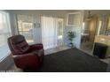 Living room with red recliner, sliding glass door, and partial kitchen view at 2205 W Klamath Ave, Apache Junction, AZ 85119