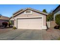 Simple one-story house with a pink garage door and small front yard at 12742 W Ash St, El Mirage, AZ 85335