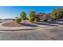 Front yard view of a one-story house with gravel landscaping and trees at 604 S 13Th Pl, Coolidge, AZ 85128