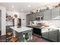 Modern kitchen with island, stainless steel appliances, and dark gray cabinets at 13928 N 145Th Ln, Surprise, AZ 85379