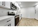 Modern kitchen with white shaker cabinets, stainless steel appliances, and quartz countertops at 1757 W Sunland Ave, Phoenix, AZ 85041