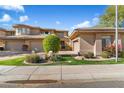 Tan two-story home with three-car garage and manicured landscaping at 15240 N Clubgate Dr # 147, Scottsdale, AZ 85254