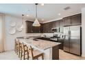 Modern kitchen with granite countertops, dark cabinetry, and stainless steel appliances at 15833 W Kendall St, Goodyear, AZ 85338