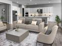 Open living area with neutral tones, a modern sofa, and a spacious kitchen at 16068 W Questa Dr, Surprise, AZ 85387