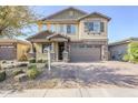 Two-story house with stone accents and a three-car garage at 25410 S 224Th Pl, Queen Creek, AZ 85142