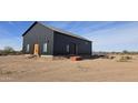 Contemporary black barn-style home with solar panels at 30314 W Wildcat Dr, Wittmann, AZ 85361