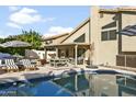 Inviting backyard oasis with a sparkling pool, patio furniture, and umbrellas at 4601 E Desert Cactus St, Phoenix, AZ 85032