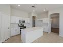 Modern kitchen with white cabinets, quartz countertops, and an island at 9443 W Melinda Ln, Peoria, AZ 85382
