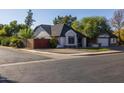 Home's exterior features a well-maintained yard and a brick facade at 1023 W Meseto Ave, Mesa, AZ 85210