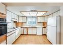 Galley-style kitchen with wood cabinets and laminate flooring at 10542 W Echo Ln, Peoria, AZ 85345