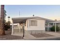 Mobile home exterior showcasing a covered carport and desert landscaping at 11411 N 91St Ave # 156, Peoria, AZ 85345