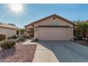 House exterior showcasing a two-car garage and drought-tolerant landscaping at 23117 W Lasso Ln, Buckeye, AZ 85326