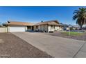Ranch style home with a large driveway and mature landscaping at 3548 W Frier Dr, Phoenix, AZ 85051
