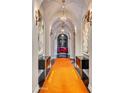 Elegant hallway with arched ceilings, a long orange runner, and statement art at 6240 N 59Th Pl, Paradise Valley, AZ 85253