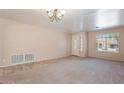 Living room with neutral walls, carpet flooring, and a view of the front door at 10419 E Kiva Ave, Mesa, AZ 85209