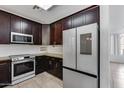 Modern kitchen featuring dark cabinets and stainless steel appliances at 17409 W Holland Ln, Surprise, AZ 85388