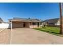 Tan brick house with carport and grassy yard at 2154 W Edgewood Ave, Mesa, AZ 85202