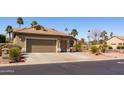 Tan one-story house with a two-car garage and desert landscaping at 2696 N 162Nd Ln, Goodyear, AZ 85395