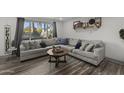 Living room featuring a gray sectional sofa, wood floors, and large window at 1407 N 44Th St, Phoenix, AZ 85008