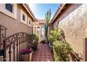 A gated courtyard with tile flooring, cacti, and lush greenery at 17937 W Weatherby Dr, Surprise, AZ 85374