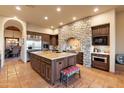 Gourmet kitchen with stone accents, island, and stainless steel appliances at 30316 N 139Th St, Scottsdale, AZ 85262