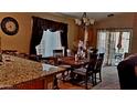 Dining area with a wooden table, chairs, and granite countertop adjacent to the kitchen at 34365 N Barzona Trl, San Tan Valley, AZ 85143