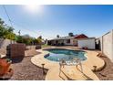 Kidney-shaped pool with surrounding patio and landscaping in the backyard at 14029 N 32Nd Pl, Phoenix, AZ 85032