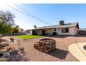 Landscaped backyard with artificial turf, fire pit, and patio area at 14029 N 32Nd Pl, Phoenix, AZ 85032