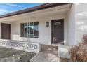 Front entry with a dark brown door, white brick, and a decorative fence at 5232 E Dodge St, Mesa, AZ 85205