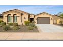 Tan house with a brown door and two car garage and desert landscaping at 12860 W Calle De Sol --, Peoria, AZ 85383