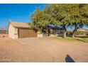 House with a two-car garage and a grassy front yard at 8926 E Malorie Ln, Coolidge, AZ 85128