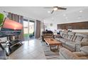 Spacious living room featuring a comfortable couch and large TV at 16406 W Charlotte Dr, Surprise, AZ 85387