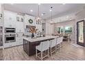 Modern kitchen with large island, stainless steel appliances, and white cabinetry at 21121 E Marsh Rd, Queen Creek, AZ 85142