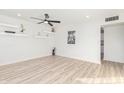 Bright and airy living room with hardwood floors and modern floating shelves at 3350 W Wethersfield Rd, Phoenix, AZ 85029