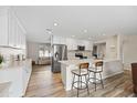 Open concept kitchen with island, stainless steel appliances, and light wood floors at 2161 E Gemini Dr, Tempe, AZ 85283