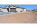 View of the home's side, showcasing the garage and a spacious lot at 27625 N Denver Hill Dr, Wittmann, AZ 85361