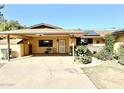 House exterior with covered carport, mature landscaping and stone accents at 404 E Paseo De Isabella --, Casa Grande, AZ 85122