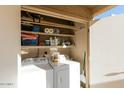 Stackable washer and dryer in a well-organized laundry closet at 1401 E Puget Ave # 24, Phoenix, AZ 85020