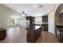 Open concept kitchen with island, dark wood cabinets, and granite countertops at 2946 E Quiet Hollow Ln, Phoenix, AZ 85024