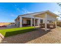 Covered patio with outdoor kitchen, lush green grass and a sparkling pool at 13930 W Tierra Grande --, Surprise, AZ 85387