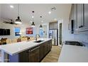 Large kitchen island with quartz countertops and a modern sink at 17221 W Middlebury St, Surprise, AZ 85388