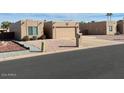 House exterior showcasing a tan stucco facade, two-car garage, and desert landscaping at 9346 E Citrus N Ln, Sun Lakes, AZ 85248