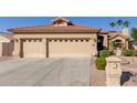 Tan house with two-car garage and driveway, desert landscaping at 3146 N 157Th Ln, Goodyear, AZ 85395