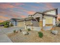 Two-story house exterior with attached garage and desert landscaping at 43576 W Snow Dr, Maricopa, AZ 85138